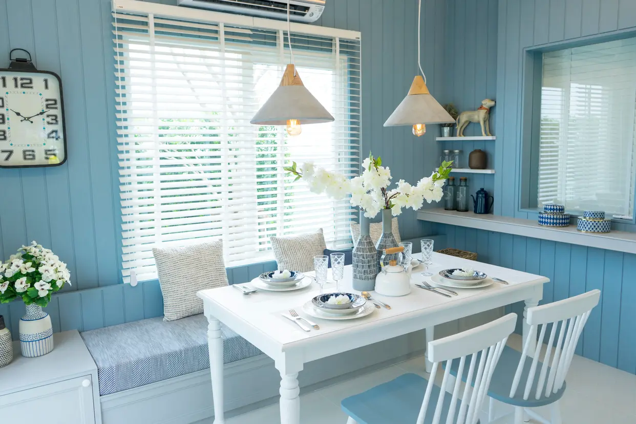Kuchnia w kolorze niebieskim z niebieskim stołem, styl hampton. Element charakterystyczny: niebieski stół