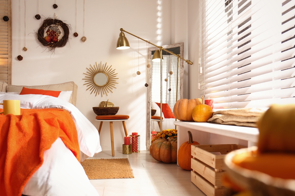 Salon w stylu boho z łóżkiem w odcieniach pomarańczu i czerwieni.