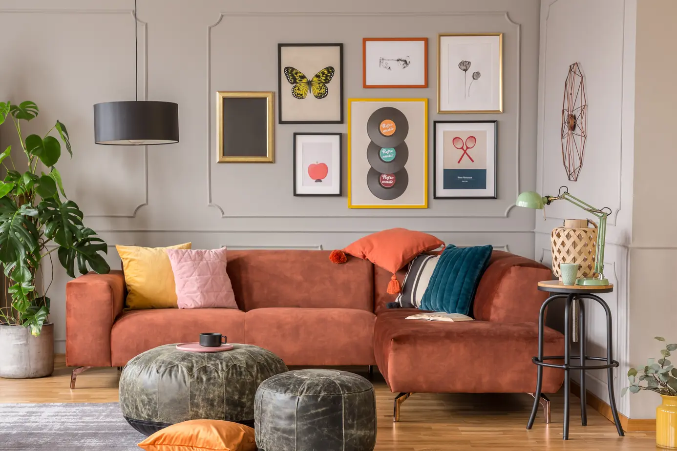 Salon w kolorze szarym z brązową kanapą, styl eklektyczny. Element charakterystyczny: brązowa kanapa. Kolor dopełniający brązowy.
