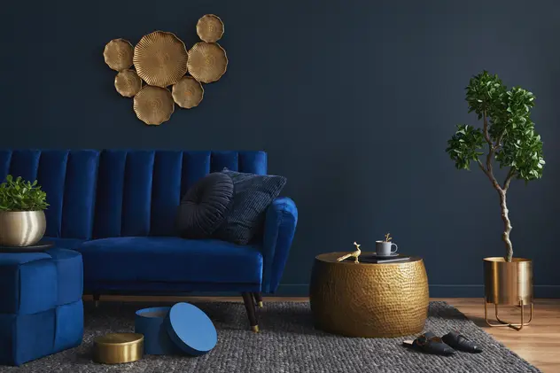 Salon w kolorze granatowym z granatową kanapą, styl glamour. Element charakterystyczny: granatowa kanapa