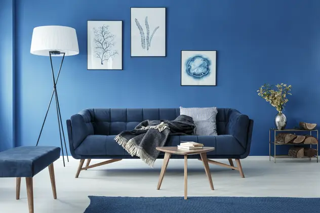 Salon w kolorze niebieskim z granatwoą kanapą, styl marynistyczny. Element charakterystyczny: granatowa kanapa