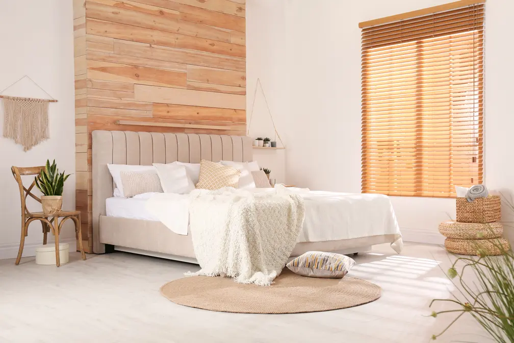 Sypialnia w kolorze białym z tapicerowanym lozkiem i drewniana scian, styl skandynawski. Element charakterystyczny: tapicerowane łóżko