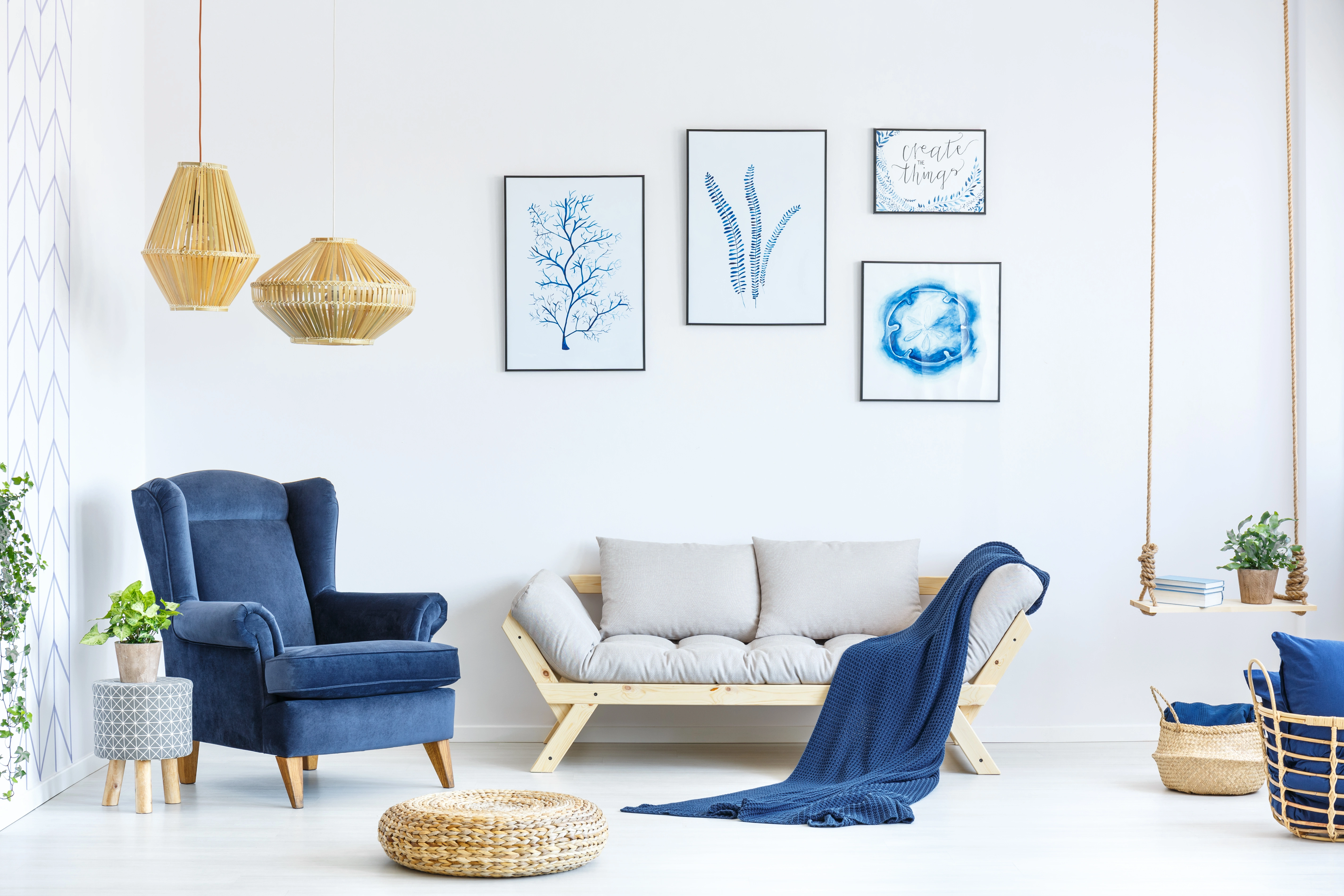 Inspiracja prezentująca salon w kolorze białym z niebieskim fotelem, styl marynistyczny. Element charakterystyczny: niebieski fotel