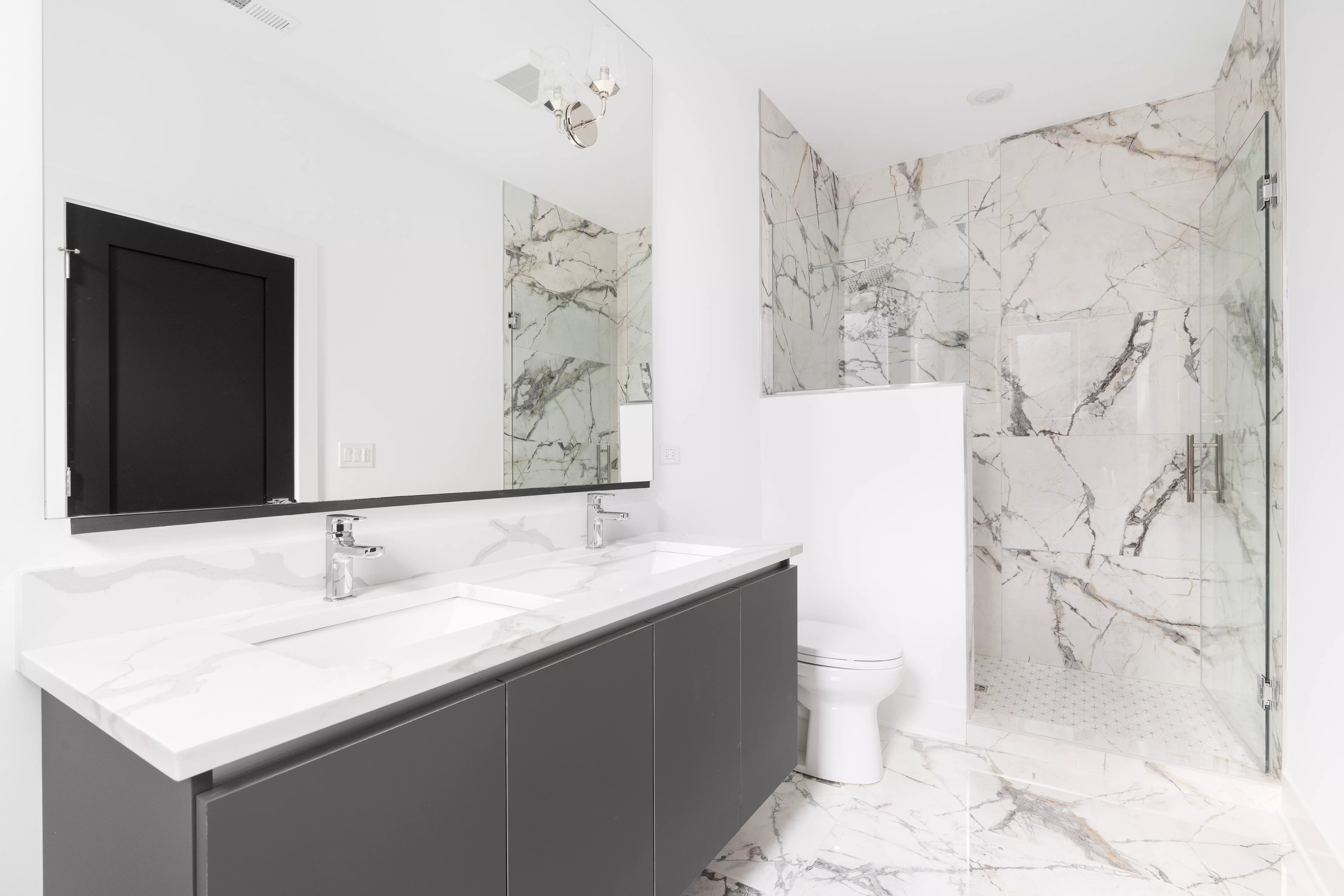 Łazienka w stylu glamour z marmurowym prysznicem. Propozycja dekoru zbliżonego kolorystycznie do aranżacji to Marmur Carrara.