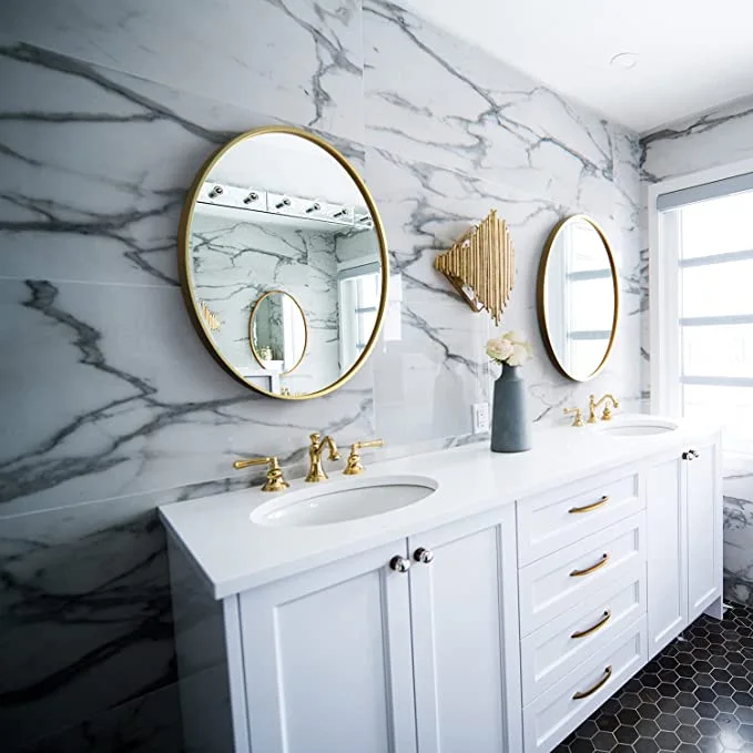 Łazienka w stylu nowojorskim ze-złotym lustrem i białą szafką ze złotymi zdobieniami