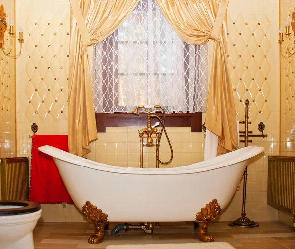 Łazienka w stylu vintage z dużą wolnostojącą wanną na złotych nogach