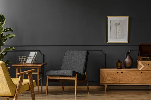 Salon w stylu vintage w ciemnych kolorach z drewnianym fotelem